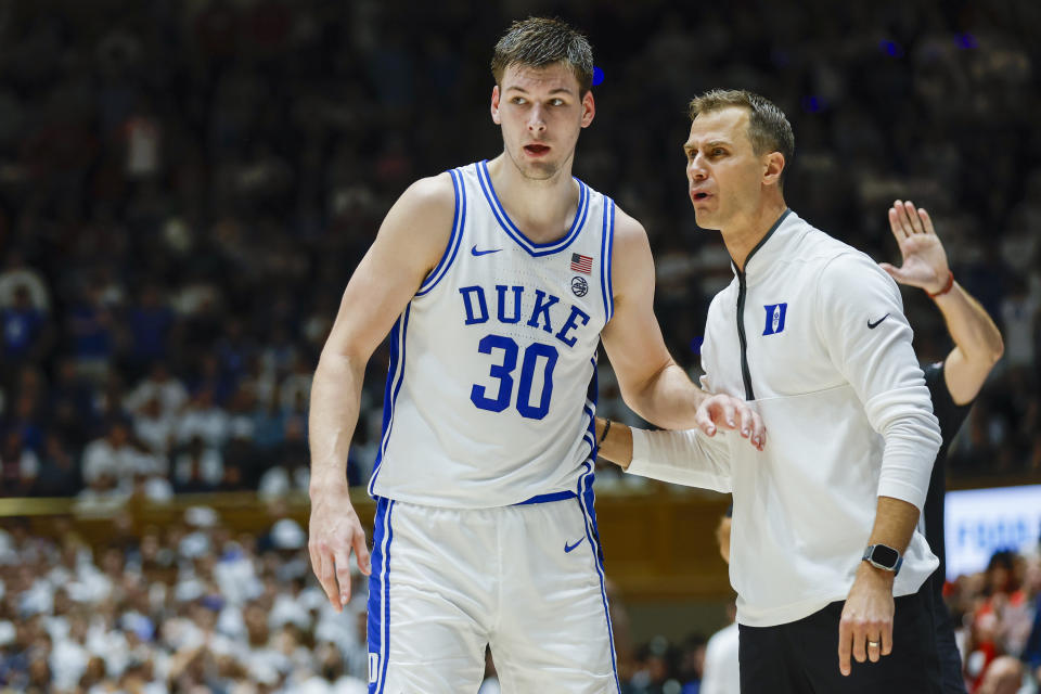 Duke head coach Jon Scheyer, right, talks to center Kyle Filipowski (30) during a break in the action in the second half against Arizona in an NCAA college basketball game in Durham, N.C., Friday, Nov. 10, 2023. (AP Photo/Nell Redmond)