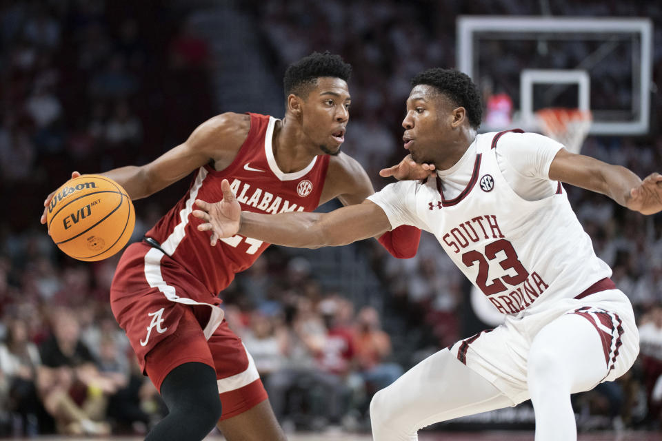 Alabama forward Brandon Miller, left, dribbles the ball against South Carolina forward Gregory Jackson II (23) during the first half of an NCAA college basketball game Wednesday, Feb. 22, 2022, in Columbia, S.C. (AP Photo/Sean Rayford)