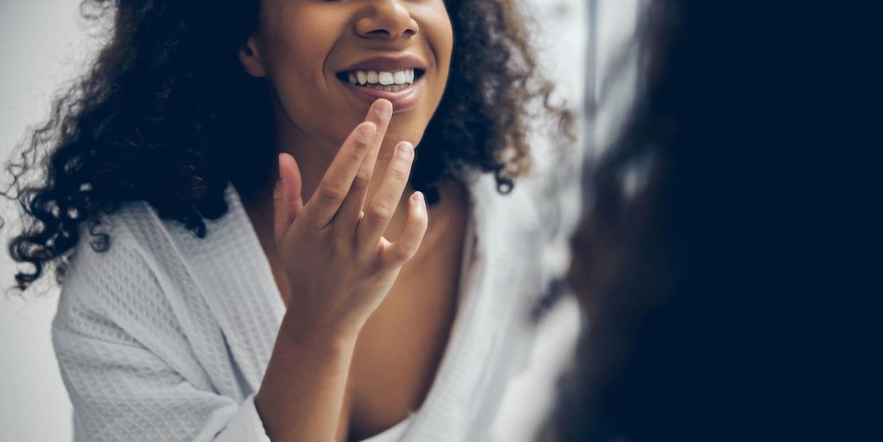 female with a happy smile examining her teeth