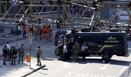 An agent of the bomb squad in protective clothing stands in the area near the finishing line of the men's cycling road race at the 2016 Rio Olympics after they made a controlled explosion, in Copacabana, Rio de Janeiro, Brazil August 6, 2016. REUTERS/Paul Hanna