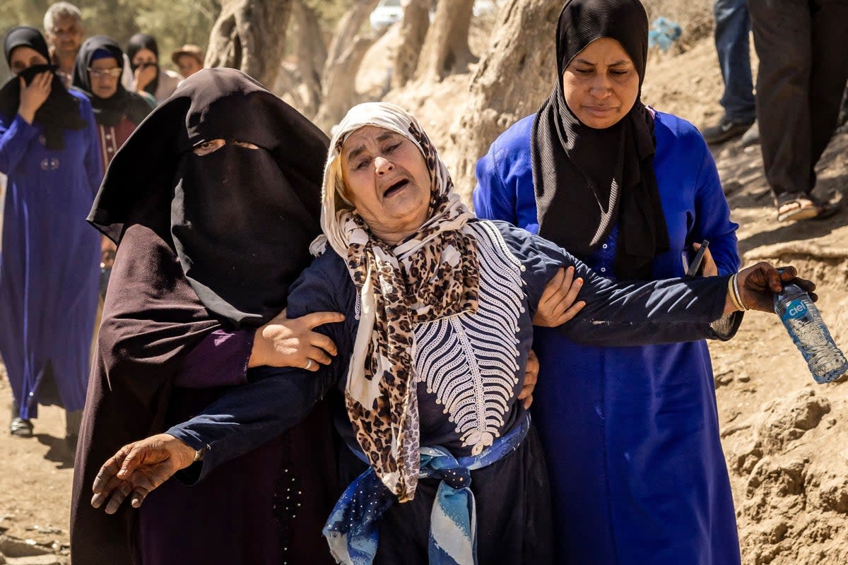 A woman is helped as she reacts to the death of relatives in the mountain village of Tafeghaghte, southwest of Marrakech  (Getty Images)