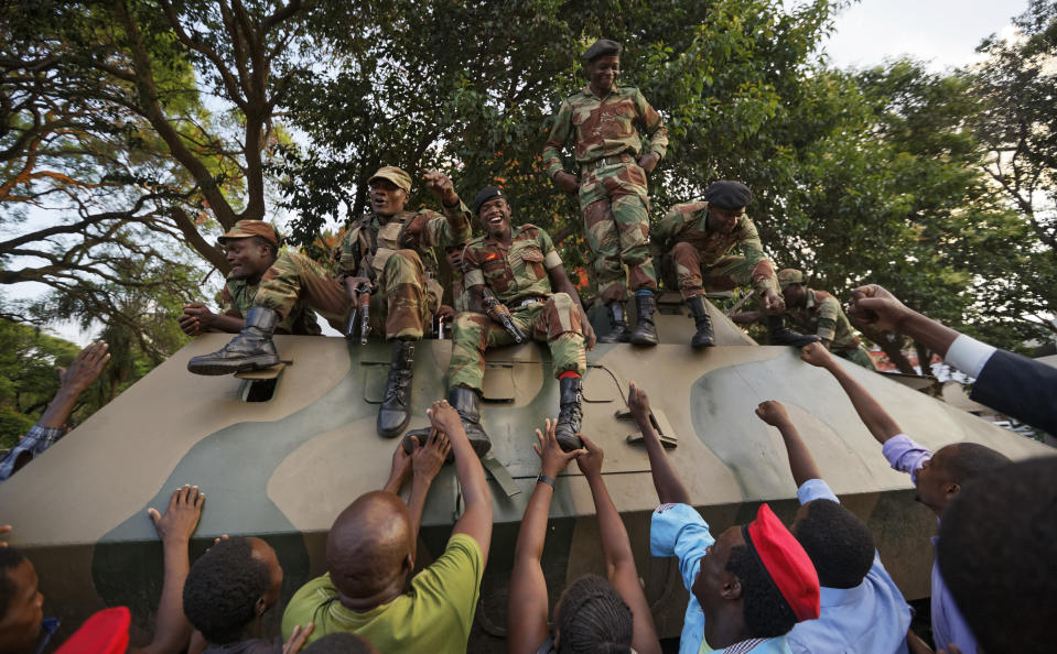 <p>Zimbabweans reach out to touch and thank army soldiers, as they celebrate outside the parliament building immediately after hearing the news that President Robert Mugabe had resigned, in downtown Harare, Zimbabwe Tuesday, Nov. 21, 2017. (Photo: Ben Curtis/AP) </p>