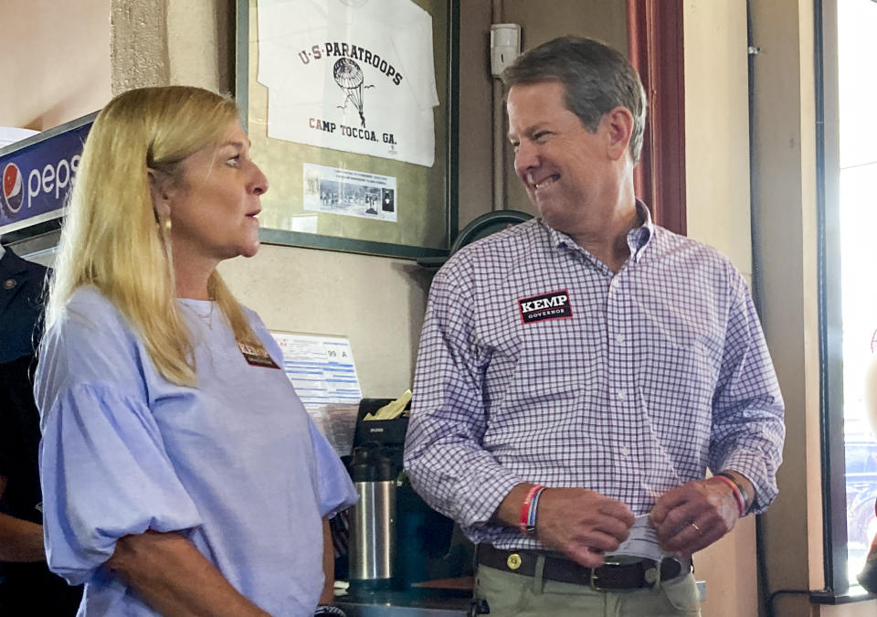 Georgia Gov. Brian Kemp, center, laughs with his wife Marty Kemp as Stephens County Commissioner Dennis Bell, right, introduces Kemp for a speech on Thursday, Aug. 4, 2022 in Toccoa, Ga. Republicans in Georgia increasingly rely on voters in north Georgia as their margins shrink in suburban Atlanta. (AP Photo/Jeff Amy)