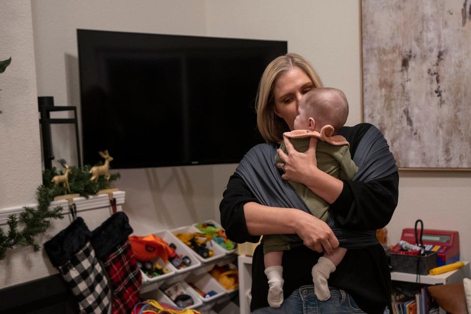 Kaitlyn Kash kisses her 4-month-old baby while spending time at her home in South Austin on Dec. 5. Kash and her husband received a devastating fetal diagnosis at 13 weeks and left the state to seek care in 2021.