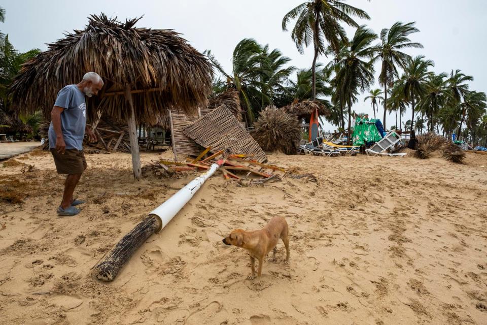 A vendor works amid the debris of his small business of umbrella rentals and food after they were felled by Hurricane Fiona on the beach in Punta Cana, Dominican Republic, Monday, Sept. 19, 2022.