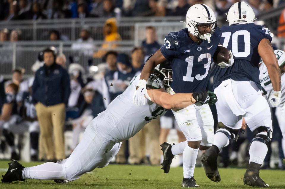 Penn State running back Kaytron Allen (13) picks up a few extra yards after contact while carrying the ball in the second quarter against Michigan State at Beaver Stadium on Saturday, Nov. 26, 2022, in State College. The Nittany Lions won, 35-16.