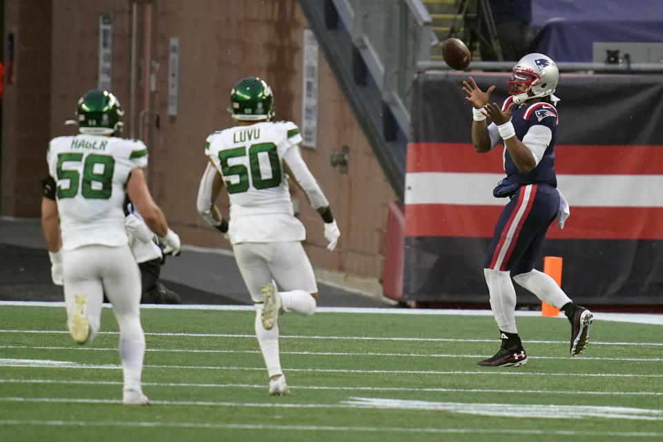 New England Patriots quarterback Cam Newton, right, catches a touchdown pass thrown by wide receiver Jakobi Meyers, as New York Jets defenders Bryce Hager, left, and Frankie Luvu give chase in the second half of an NFL football game, Sunday, Jan. 3, 2021, in Foxborough, Mass. (AP Photo/Charles Krupa)