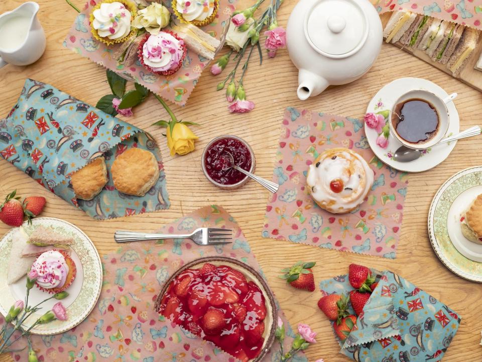 Beeswax food wrapping pictured on a table with tea and cakes