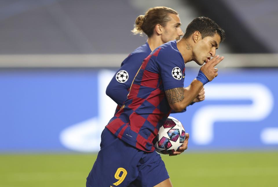 Barcelona's Luis Suarez, right, celebrates with Barcelona's Antoine Griezmann after scoring a goal during the Champions League quarterfinal soccer match between Barcelona and Bayern Munich in Lisbon, Portugal, Friday, Aug. 14, 2020. (Rafael Marchante/Pool via AP)