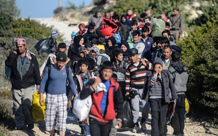 Turkish police in Cesme on November 5, 2015 escort migrants to buses as an alternative to sailing via raft to the Greek island of Chios (AFP Photo/Bulent Kilic)