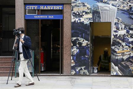 A journalist walks past a hoarding showing the Walkie Talkie tower in London September 3, 2013. REUTERS/Stefan Wermuth