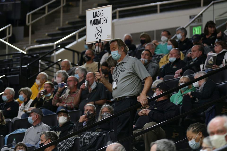 A "Masks Mandatory" sign is paraded through the stands during the third quarter of an NCAA women's basketball game, Sunday, Nov. 14, 2021 at Mackey Arena in West Lafayette.