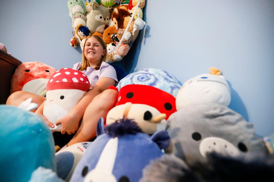 Eleven-year-old Jessica Strickland sits among her collection of around 100 Squishmallows that she has been collecting for nearly two years. Strickland said she saves up her allowance and does odd jobs for her neighbors in order to expand her collection.