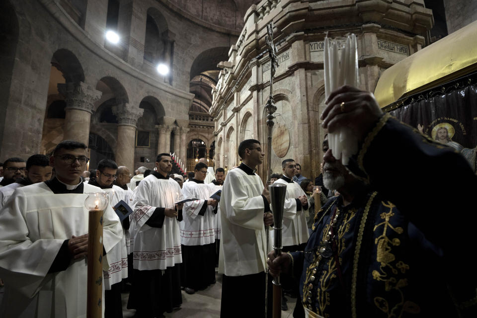 Catholic clergy hold candles during the Holy Thursday procession at the Church of the Holy Sepulcher, the site where according to tradition Jesus was crucified and buried, in the Old City of Jerusalem, Thursday, April 6, 2023. (AP Photo/Maya Alleruzzo)