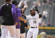 Teammates run to Colorado Rockies pinch-hitter Charlie Blackmon, right, to celebrate after his walkoff, RBI-single off San Diego Padres relief pitcher Austin Adams in the ninth inning of a baseball game Wednesday, June 16, 2021, in Denver. The Rockies won 8-7 to sweep the three-game set. (AP Photo/David Zalubowski)