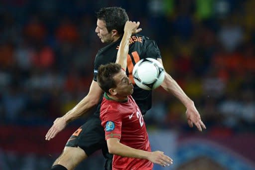 Dutch forward Robin van Persie (back) and Portuguese defender Joao Pereira jump for a header during the Euro 2012 football championships match Portugal vs. Netherlands at the Metalist stadium in Kharkiv. Portugal beat the Netherlands 2-1 on Sunday to set up a Euro 2012 quarter-final with the Czech Republic and condemn the Dutch to a first group-stage European Championship exit since 1980