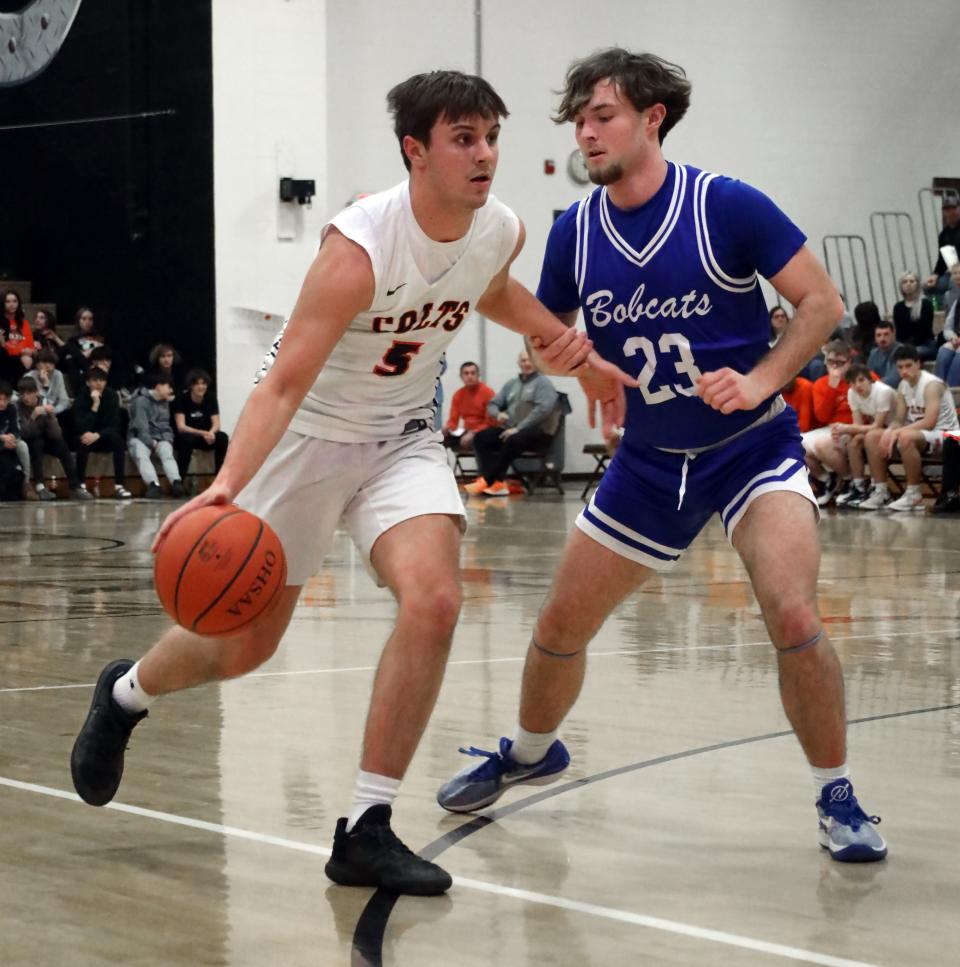 Meadowbrook's Colton Delancey (5) dribbles the ball during the Colts versus Bobcats basketball game Tuesday evening at Meadowbrook High School.