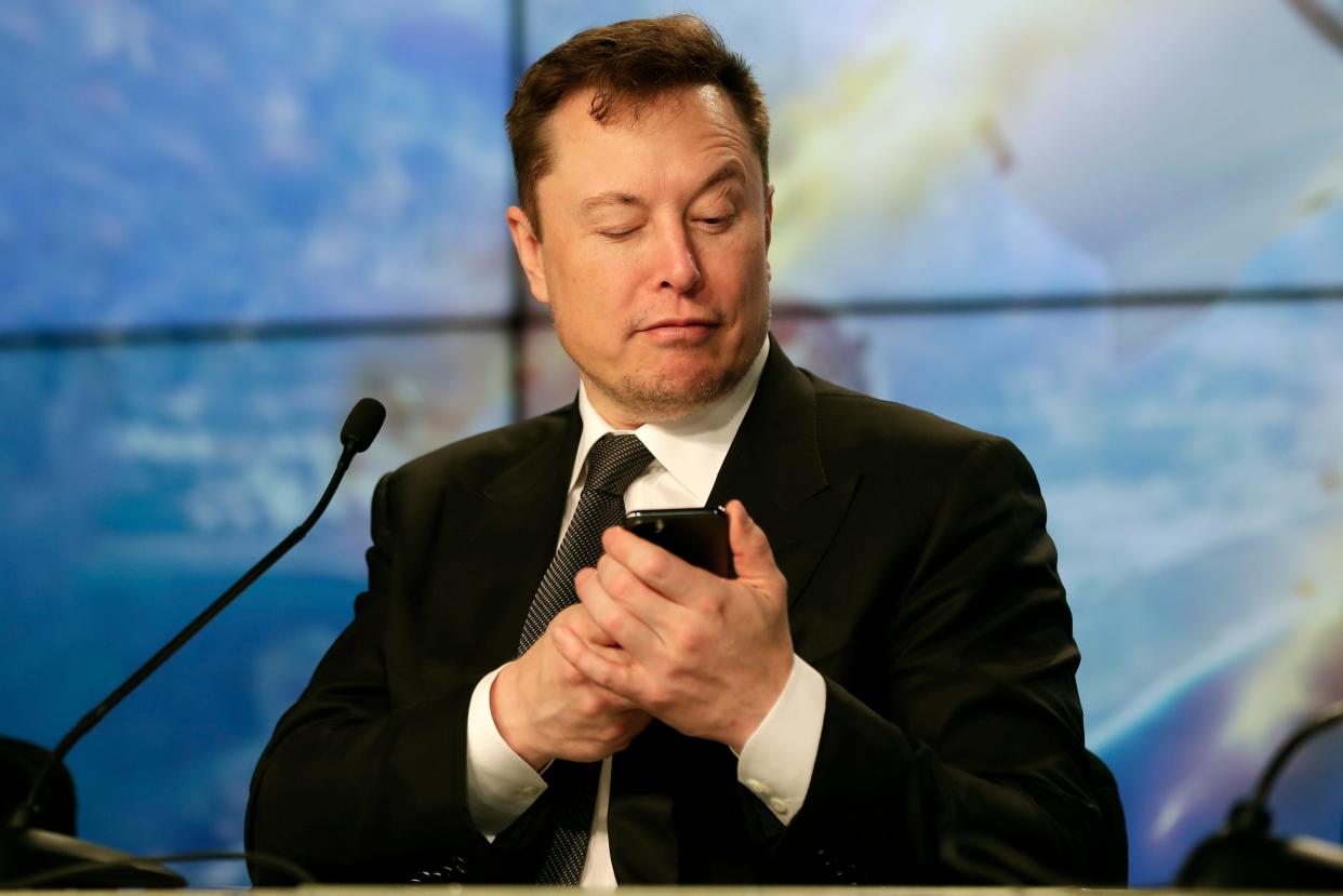 Elon Musk looking at his phone.