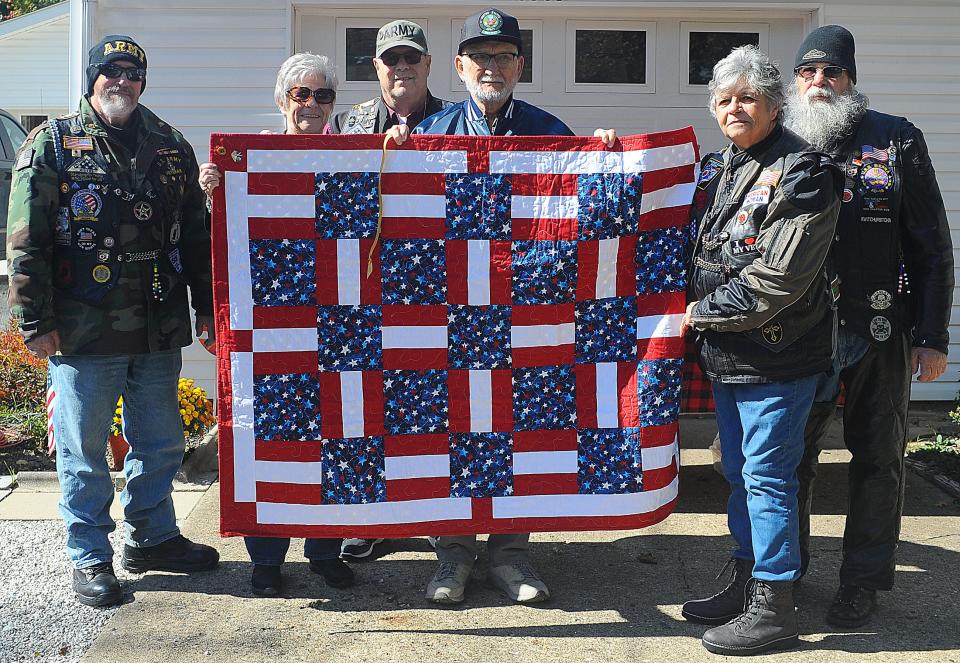 Kenneth Harper, center, holds a Quilt of Honor that he received Saturday Oct. 8, 2022, from members of the Patriot Guard Riders, from left, Ralph Olbon, Melissa Seibert, Jim Myers, Jennifer Gerrick and John Bowman as part of the Honoring Our True Heroes mission.