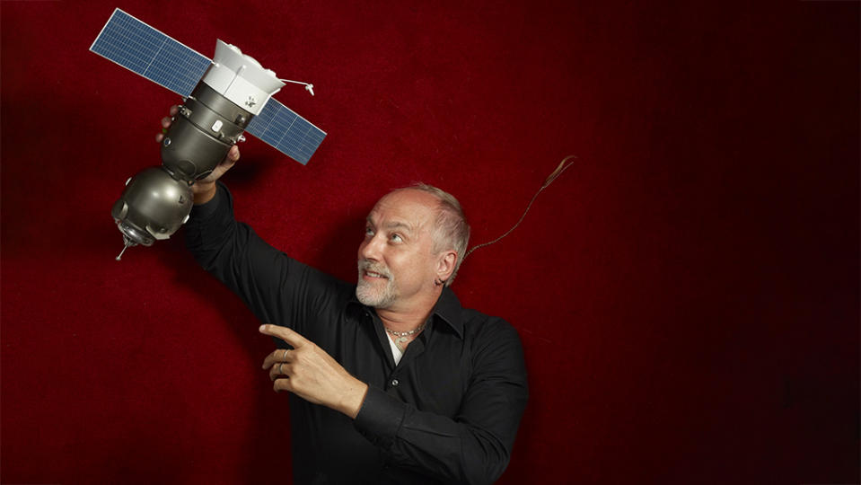 Garriott with a model of the Soyuz TMA-13 orbital module, where he lived for two days before docking at the International Space Station. - Credit: Chris Buck