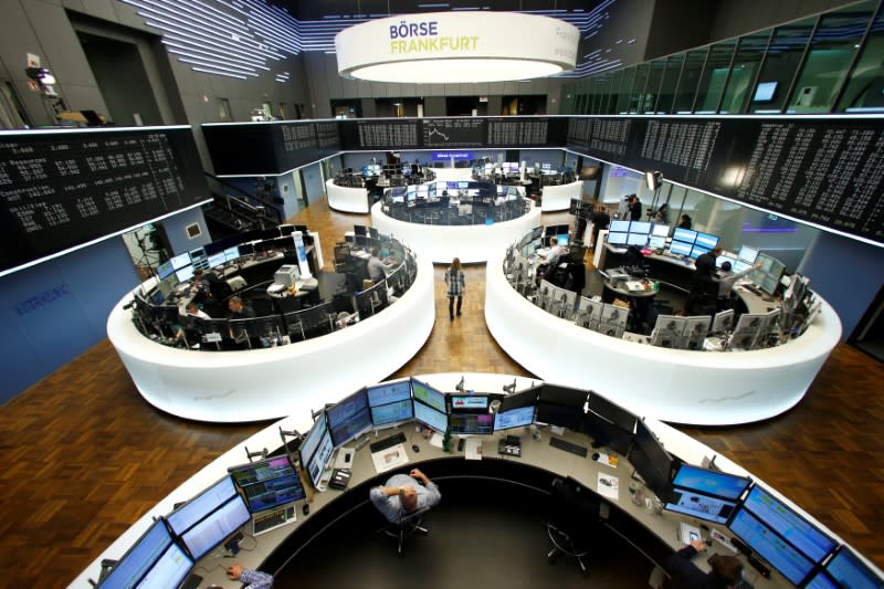Traders work at their desks in front of the German share price index, DAX board, at the stock exchange in Frankfurt, Germany, February 15, 2017. REUTERS/Ralph Orlowski