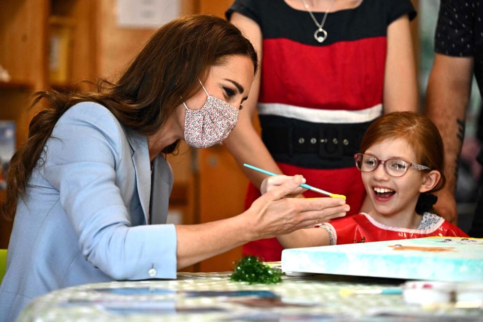 Catherine, Duchess of Cambridge, gets her palm painted by Willow Bamber during a visit to East Anglia's Children's Hospices (EACH) in Milton