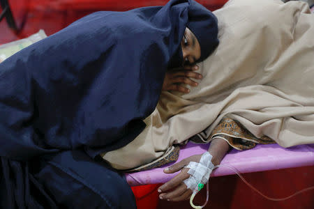 A woman comforts her husband suffering from severe diarrhoea at a dysentery clinic run by Medical Teams International in Kutupalong camp near Cox's Bazar, Bangladesh October 6, 2017. REUTERS/Damir Sagolj