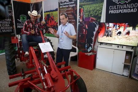 Saul Berenthal (R), co-owner of the tractor factory Oggun in Alabama, talks to a potential client at the International Agro-Industrial and Food Fair in Havana March 14, 2016. REUTERS/Alexandre Meneghini