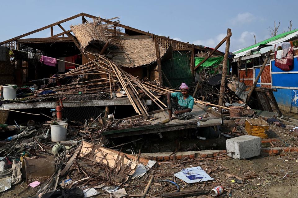 A Rohingya woman sits by her destroyed house at Ohn Taw Chay refugee camp in Sittwe, Rakhine state, Myanmar, May 16, 2023, in the aftermath of Cyclone Mocha's landfall. / Credit: SAI AUNG MAIN/AFP/Getty