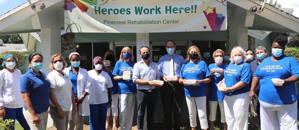 Miami Woman’s Club members, in blue shirts, deliver meals to the staff at Pinecrest Rehabilitation Center in North Miami. At the center in a black mask is Café Cream owner Cory Finot, with David Long from Pinecrest Rehabilitation Center and Miami Woman’s Club President Shirley Pardon.