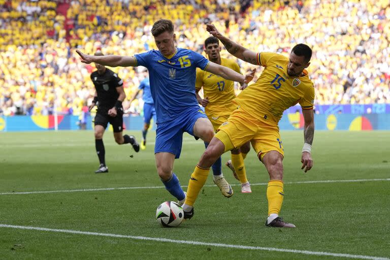 El ucraniano Viktor Tsyhankov y el rumano Andrei Burca disputan un balón