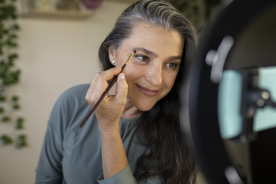 mature woman filling in eyebrows