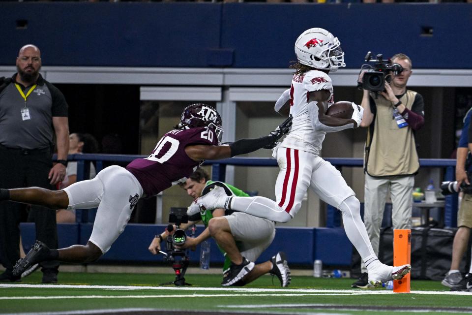 Sep 24, 2022; Arlington, Texas, USA; Arkansas Razorbacks wide receiver Ketron Jackson Jr. (2) scores a touchdown as Texas A&M Aggies defensive back Jardin Gilbert (20) defends during the first quarter at AT&T Stadium. Mandatory Credit: Jerome Miron-USA TODAY Sports