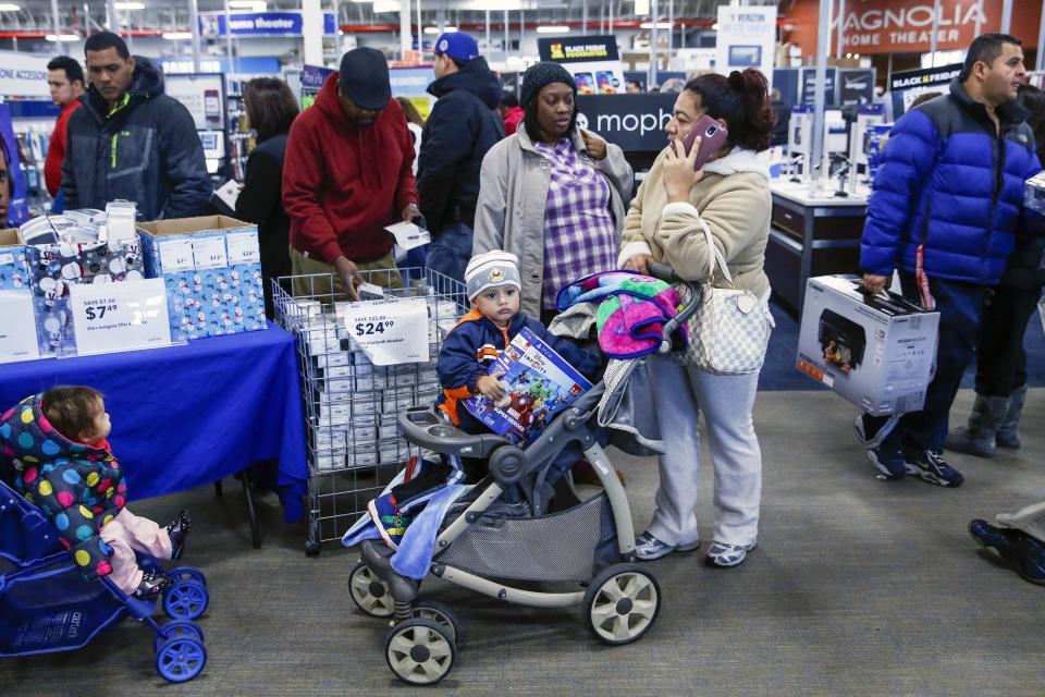 A child sits in a stroller holding an electronic item at a Best Buy store in Westbury, New York