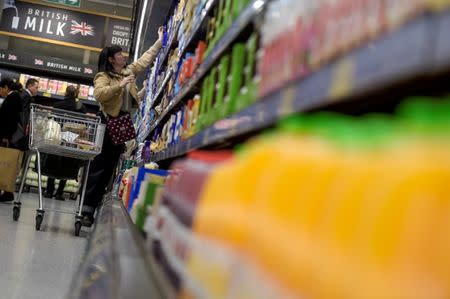 FILE PHOTO: A shopper reaches to a high shelf in an Aldi store in London, Britain February 15, 2018. REUTERS/Peter Summers/File Photo