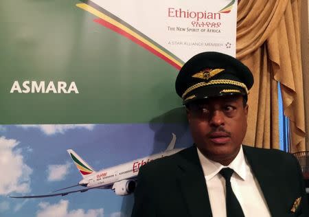 Ethiopian Airlines Captain Yoseph Hailu stands near a banner advertising the Asmara route during a ceremony at the Bole International Airport in Addis Ababa, Ethiopia July 18, 2018. REUTERS/Tiksa Negeri