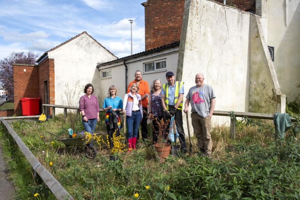 a group of people standing on scrubland