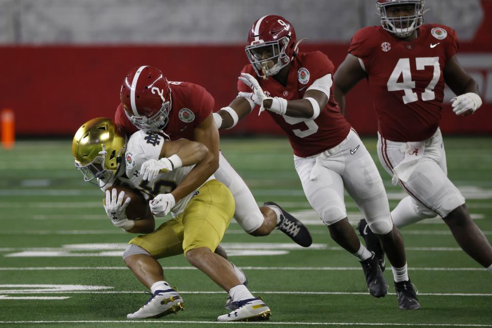 Notre Dame running back Chris Tyree (25) is stopped by Alabama defensive back Patrick Surtain II (2) with help from defensive back Jordan Battle (9) and defensive lineman Byron Young (47) in the second half of the Rose Bowl NCAA college football game in Arlington, Texas, Friday, Jan. 1, 2021. (AP Photo/Ron Jenkins)