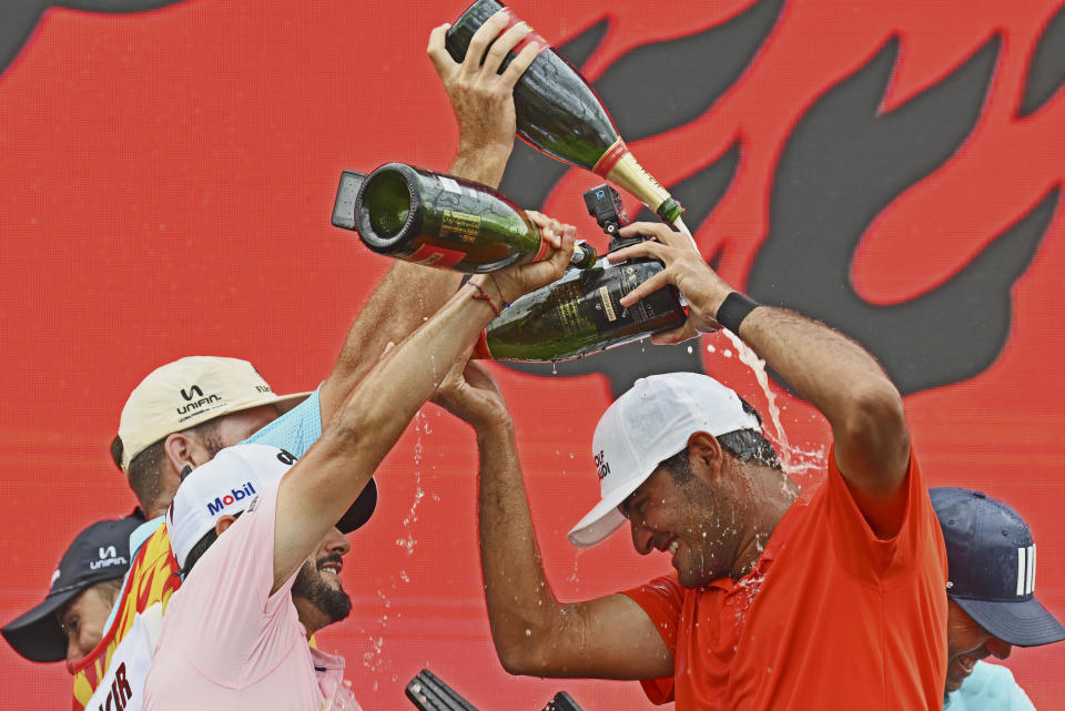 Eugenio Lopez-Chacarra, right, from Spain is sprayed in Champagne by teammates after winning the LIV Golf Invitational Bangkok 2022 at Stonehill Golf Club in Pathum Thani, Thailand, Sunday, Oct. 9, 2022. (AP Photo/Kittinun Rodsupan)