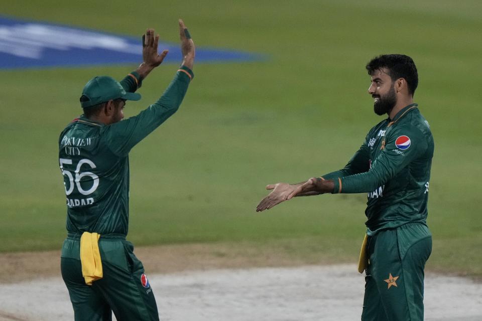 Pakistan's Shadab Khan, right, celebrates with teammate Babar Azam after taking the wicket of Hong Kong's Aizaz Khan during the T20 cricket match of Asia Cup between Pakistan and Hong Kong, in Sharjah, United Arab Emirates, Friday, Sept. 2, 2022. (AP Photo/Anjum Naveed)