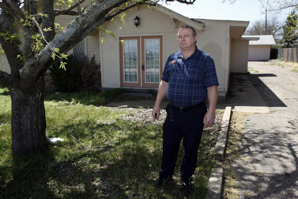 Realtor Rick Cumins poses for a picture outside of a house that he's been trying to sell for six months in Cleburn, Texas March 24, 2009. Small-town Texan realtor Cumins is going to see a paycheck in April -- his first since December. REUTERS/Jessica Rinaldi (UNITED STATES BUSINESS)