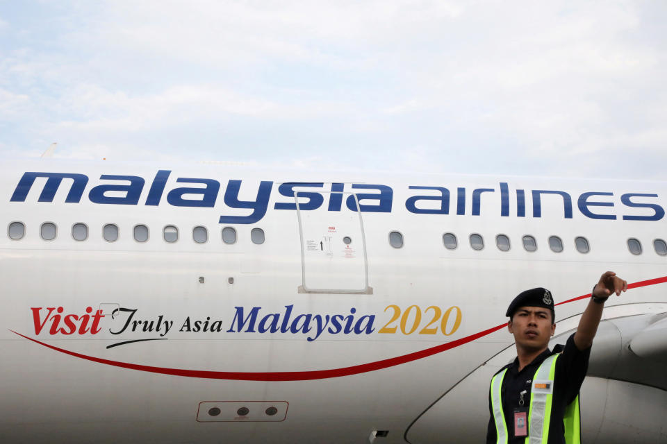 Airport staff works beside a Malaysia Airlines plane at Kuala Lumpur International Airport in Sepang