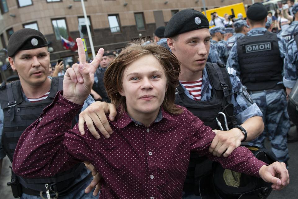 Police officers detain a young protester during a march in Moscow, Russia, Wednesday, June 12, 2019. Police and hundreds of demonstrators are facing off in central Moscow at an unauthorized march against police abuse in the wake of the high-profile detention of a Russian journalist. More than 20 demonstrators have been detained, according to monitoring group. (AP Photo/Alexander Zemlianichenko)