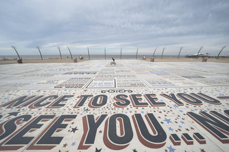 A cyclist rides along an unusually quiet promenade in Blackpool, northwest England, Sunday, April 5, 2020 as a bout of warm weather has raised fears that the public may not observe the British government guidelines that include two metres social distancing from people that don't live in the same household, to help stop the spread of coronavirus. The new coronavirus causes mild or moderate symptoms for most people, but for some, especially older adults and people with existing health problems, it can cause more severe illness or death. (AP Photo/Jon Super)