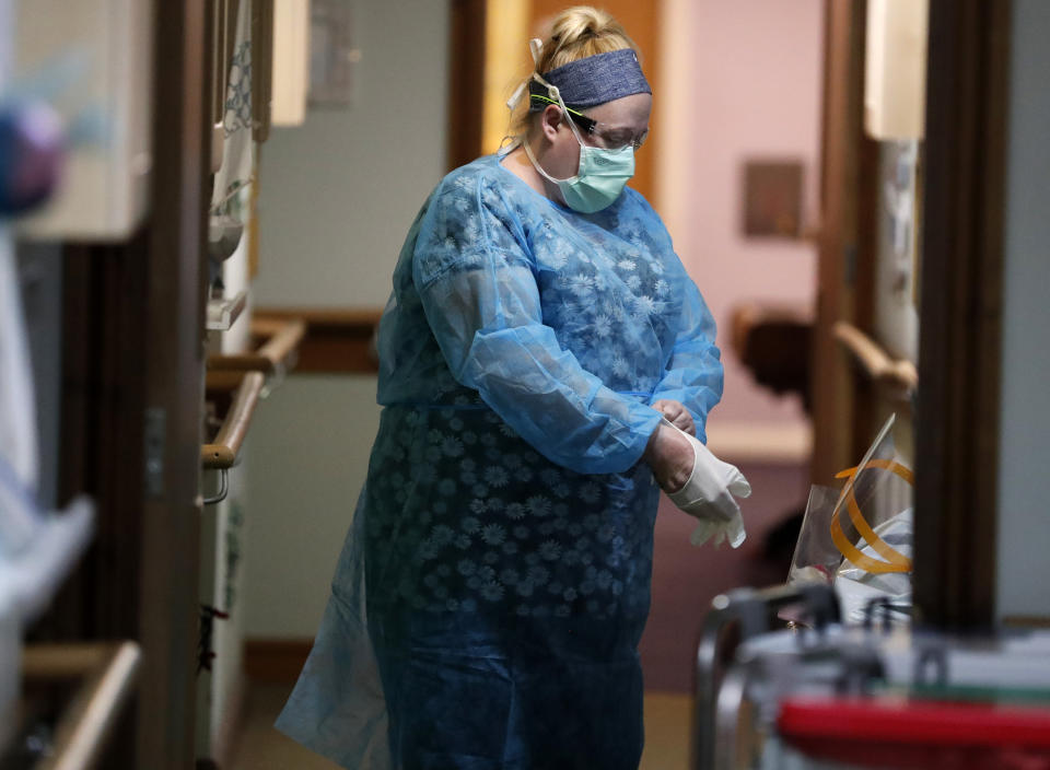 A nurse puts on PPE (personal protective equipment) at the Wren Hall care home in Nottingham, Monday, April 20, 2020. AP visited a care home in Nottingham where 10 of their 54 residents have succumbed to coronavirus. Leading British charities said the new coronavirus is causing "devastation" in the country's nursing homes, as official statistics show that hundreds more people with COVID-19 have died than are recorded in the U.K. government's daily tally. (AP Photo/Frank Augstein)