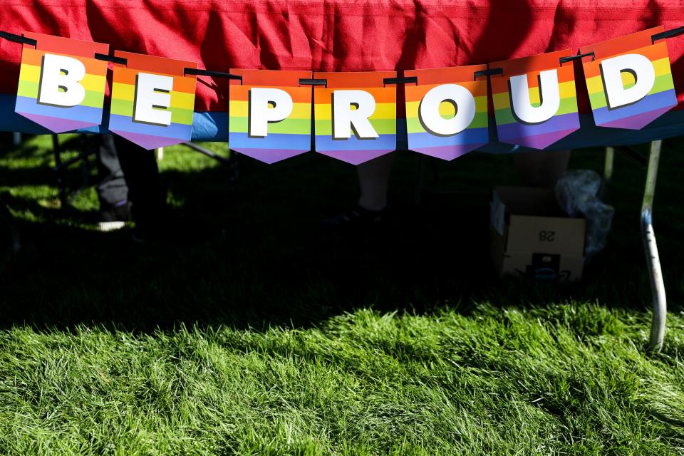 A Pride banner hangs from the Confluence Willamette Valley LGBT Chorus' booth during Salem's 2022 Pride in the Park.