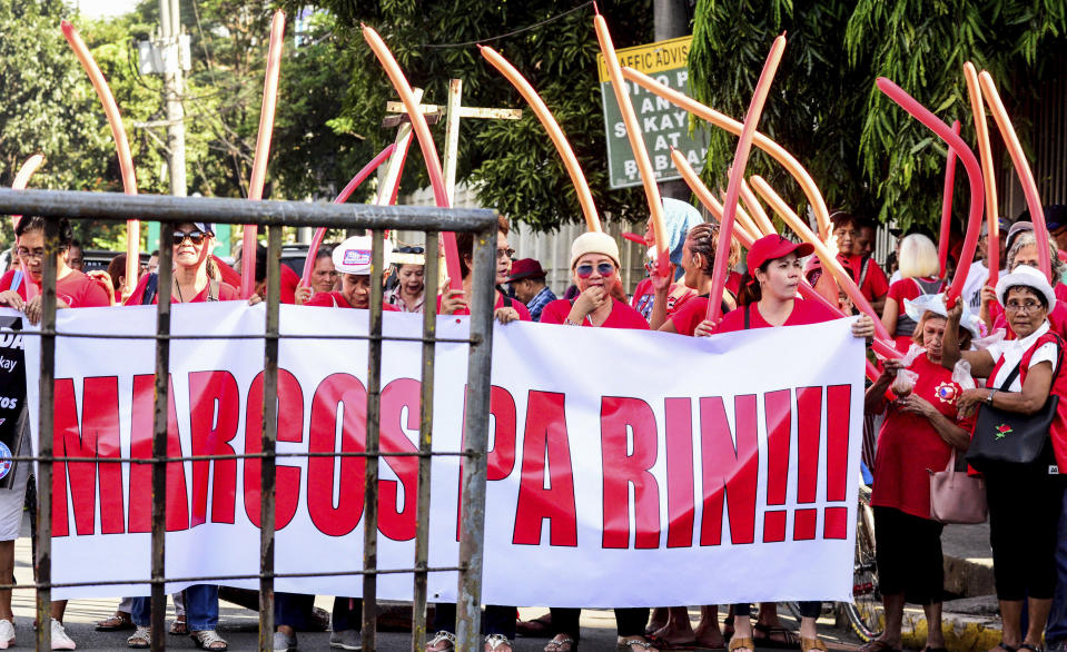 Supporters of former Philippine First Lady Imelda Marcos gather outside the anti-graft court Sandiganbayan to await her arrival following the Court's order for her to appear to explain her side for not attending last week's promulgation of the graft charges against her Friday, Nov. 16, 2018 in suburban Quezon city northeast of Manila, Philippines. A Philippine court found Imelda Marcos guilty of graft and ordered her arrest last week in a rare conviction among many corruption cases that she's likely to appeal to avoid jail and losing her seat in Congress. The banner reads: Marcos' Still.! (AP Photo/Maria S. Tan)