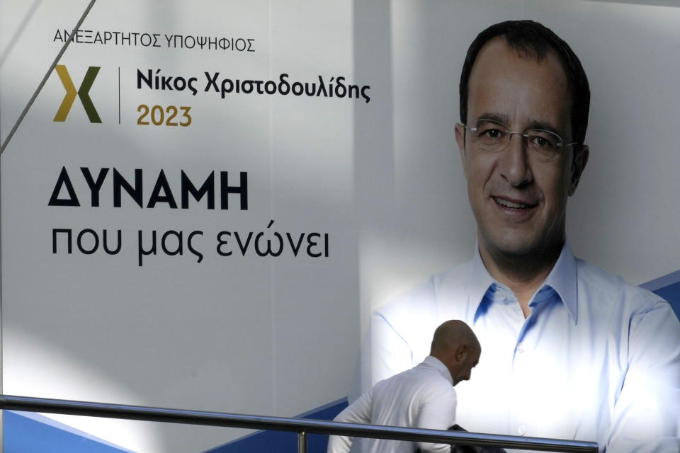 A man walks past the campaign headquarters of presidential candidate Nikos Christodoulides, with Greek that reads: "Force that Unites Us", in capital Nicosia, Cyprus, Wednesday, Feb. 8, 2023. A youthful former foreign minister who campaigned as a unifier unconstrained by antiquated ideological and party lines will take on a veteran diplomat with broad voter appeal in a Feb. 12 runoff for the presidency of ethnically divided Cyprus. Cyprus' former top diplomat Nikos Christodoulides, 49, came out on top with 32% of the vote in the Feb. 5 first round. Andreas Mavroyiannis, 66, clinched second place with a surprisingly strong showing of 29.6% of votes. (AP Photo/Petros Karadjias)
