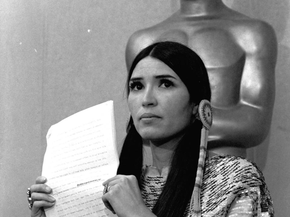 Sacheen Littlefeather, pictured at the 1973 Oscars ceremony, tells the audience that Marlon Brando was declining to accept his award. The move was meant to protest Hollywood's treatment of Native Americans. (The Associated Press - image credit)