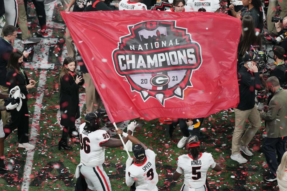 Georgia players wave a championship flag after defeating Alabama.